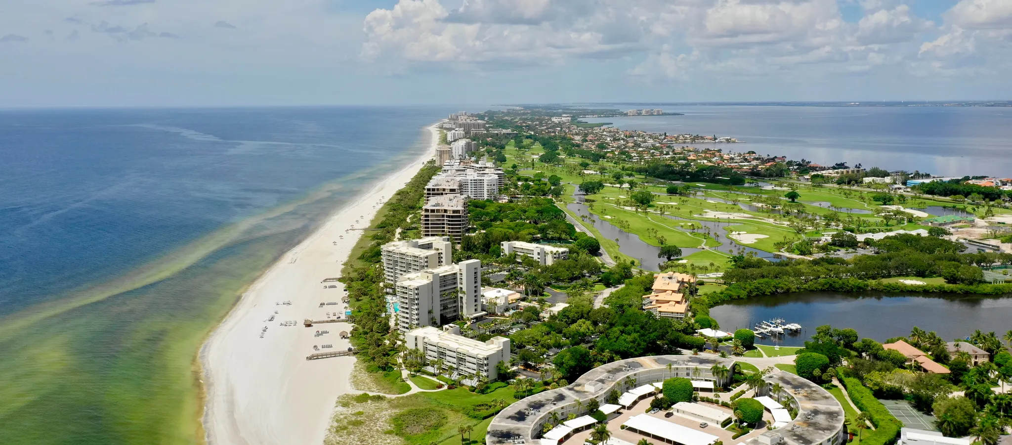 Nice real estate area with long beaches. Red tide in Sarasota. Vacant beach and green turbid waters just off Longboat Key - Sarasota, Florida. A stock photo.