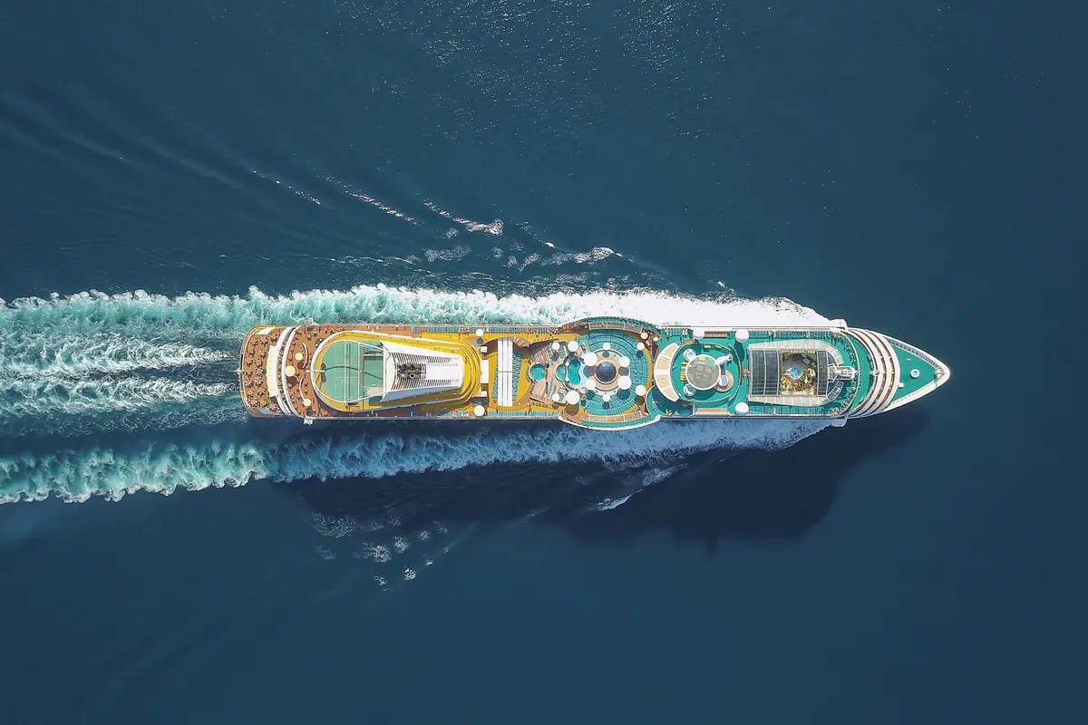 Aerial view large cruise ship sailing across a blue sea. View from a drone. A luxury and wealth themed stock photo..